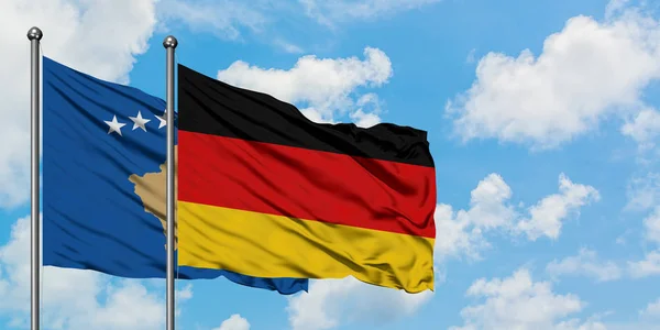 Kosovo e Germania bandiera sventolando nel vento contro bianco cielo blu nuvoloso insieme. Concetto di diplomazia, relazioni internazionali . — Foto Stock