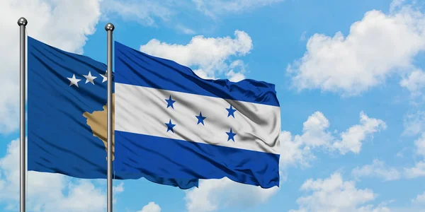Bandera de Kosovo y Honduras ondeando en el viento contra el cielo azul nublado blanco juntos. Concepto diplomático, relaciones internacionales . — Foto de Stock
