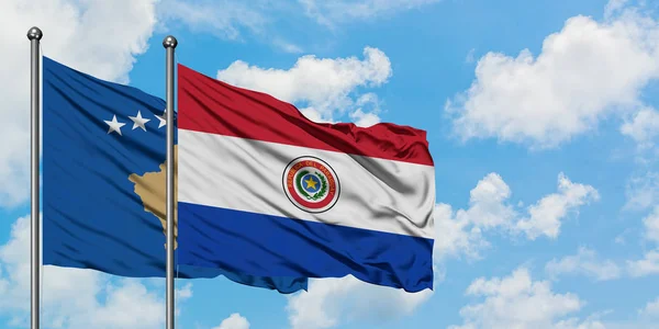 Косово и Парагвай вместе размахивают на ветру белым облачным голубым небом. Концепция дипломатии, международные отношения . — стоковое фото