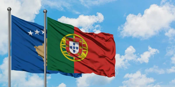 Bandera de Kosovo y Portugal ondeando en el viento contra el cielo azul nublado blanco juntos. Concepto diplomático, relaciones internacionales . — Foto de Stock