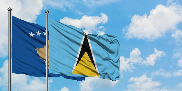 코소보와 세인트 루시아 깃발이 하얀 흐린 푸른 하늘을 배경으로 바람에 흔들리고 있습니다. 외교 개념, 국제 관계. — 스톡 사진