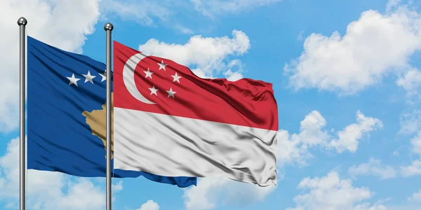 Kosovo e Singapura acenando com a bandeira no vento contra o céu azul nublado branco juntos. Conceito de diplomacia, relações internacionais . — Fotografia de Stock