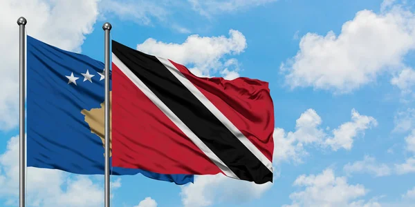 Kosova ve Trinidad ve Tobago bayrağı birlikte beyaz bulutlu mavi gökyüzüne karşı rüzgarda sallayarak. Diplomasi kavramı, uluslararası ilişkiler. — Stok fotoğraf