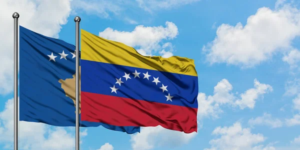 A bandeira do Kosovo e da Venezuela agitando no vento contra o céu azul nublado branco juntos. Conceito de diplomacia, relações internacionais . — Fotografia de Stock