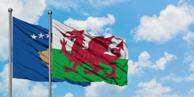 Kosova ve Galler bayrağı birlikte beyaz bulutlu mavi gökyüzüne karşı rüzgarda sallayarak. Diplomasi kavramı, uluslararası ilişkiler.