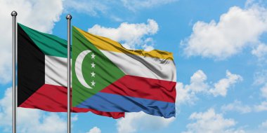 Kuveyt ve Komorbayrağı birlikte beyaz bulutlu mavi gökyüzüne karşı rüzgarda sallayarak. Diplomasi kavramı, uluslararası ilişkiler.