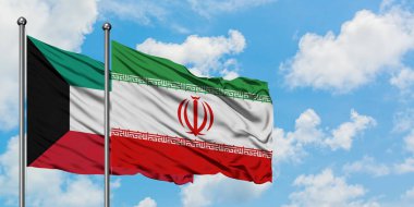 Kuveyt ve İran bayrağı birlikte beyaz bulutlu mavi gökyüzüne karşı rüzgarsal sallayarak. Diplomasi kavramı, uluslararası ilişkiler.