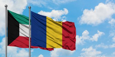 Kuveyt ve Romanya bayrağı birlikte beyaz bulutlu mavi gökyüzüne karşı rüzgarda sallayarak. Diplomasi kavramı, uluslararası ilişkiler.