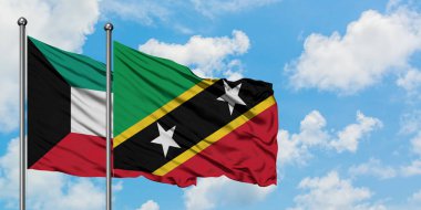 Kuveyt ve Saint Kitts ve Nevis bayrağı birlikte beyaz bulutlu mavi gökyüzüne karşı rüzgarda sallayarak. Diplomasi kavramı, uluslararası ilişkiler.