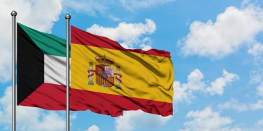 Kuveyt ve İspanya bayrağı birlikte beyaz bulutlu mavi gökyüzüne karşı rüzgarsal sallayarak. Diplomasi kavramı, uluslararası ilişkiler.