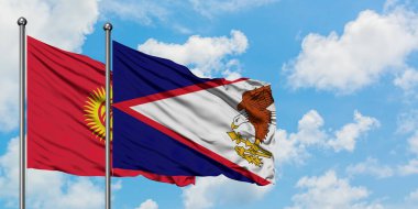 Kırgızistan ve Amerikan Samoası bayrağı birlikte beyaz bulutlu mavi gökyüzüne karşı rüzgarda sallayarak. Diplomasi kavramı, uluslararası ilişkiler.