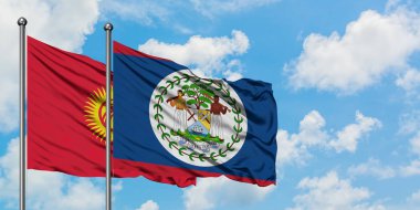 Kırgızistan ve Belize bayrağı birlikte beyaz bulutlu mavi gökyüzüne karşı rüzgarda sallayarak. Diplomasi kavramı, uluslararası ilişkiler.