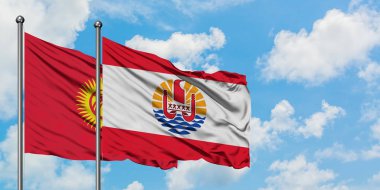 Kırgızistan ve Fransız Polinezyası bayrağı birlikte beyaz bulutlu mavi gökyüzüne karşı rüzgarda sallayarak. Diplomasi kavramı, uluslararası ilişkiler.