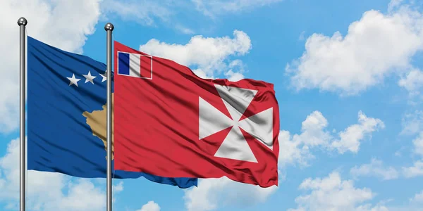 Kosovo y Wallis Y la bandera de Futuna ondeando en el viento contra el cielo azul nublado blanco juntos. Concepto diplomático, relaciones internacionales . — Foto de Stock