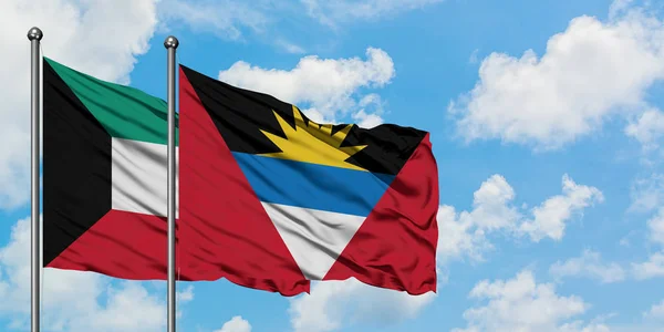 Kuveyt ve Antigua ve Barbuda bayrağı birlikte beyaz bulutlu mavi gökyüzüne karşı rüzgarda sallayarak. Diplomasi kavramı, uluslararası ilişkiler. — Stok fotoğraf
