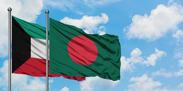 Bandera de Kuwait y Bangladesh ondeando en el viento contra el cielo azul nublado blanco juntos. Concepto diplomático, relaciones internacionales . — Foto de Stock