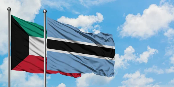 Kuwait and Botswana flag waving in the wind against white cloudy blue sky together. Diplomacy concept, international relations. — Stock Photo, Image