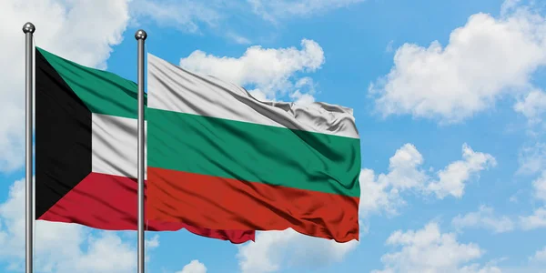 Bandera de Kuwait y Bulgaria ondeando en el viento contra el cielo azul nublado blanco juntos. Concepto diplomático, relaciones internacionales . — Foto de Stock