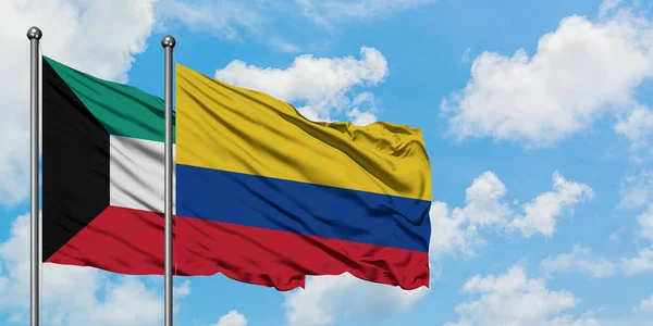 Η σημαία του Κουβέιτ και της Κολομβίας κουνώντας τον άνεμο ενάντια στον λευκό νεφελώδες γαλάζιο ουρανό μαζί. Φιλοσοφία της διπλωματίας, διεθνείς σχέσεις. — Φωτογραφία Αρχείου