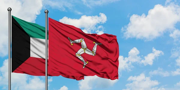 Koeweit en Isle of man vlag zwaaien in de wind tegen witte bewolkte blauwe hemel samen. Diplomatie concept, internationale betrekkingen. — Stockfoto