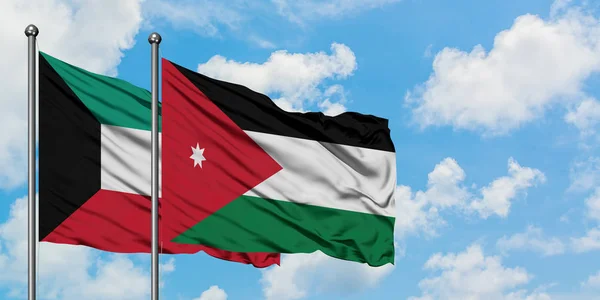 Bandera de Kuwait y Jordania ondeando en el viento contra el cielo azul nublado blanco juntos. Concepto diplomático, relaciones internacionales . — Foto de Stock