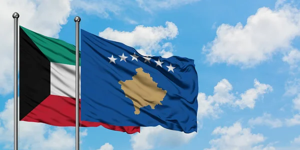 Bandera de Kuwait y Kosovo ondeando en el viento contra el cielo azul nublado blanco juntos. Concepto diplomático, relaciones internacionales . — Foto de Stock