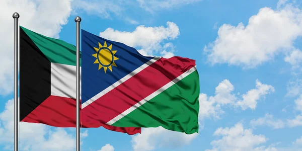 Kuvait és Namíbia zászló integetett a szél ellen, fehér felhős kék ég együtt. Diplomáciai koncepció, nemzetközi kapcsolatok. — Stock Fotó