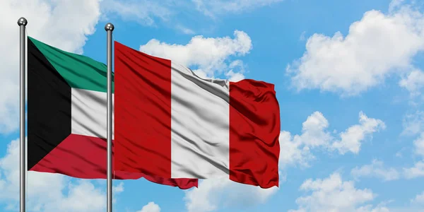 Bandera de Kuwait y Perú ondeando en el viento contra el cielo azul nublado blanco juntos. Concepto diplomático, relaciones internacionales . — Foto de Stock