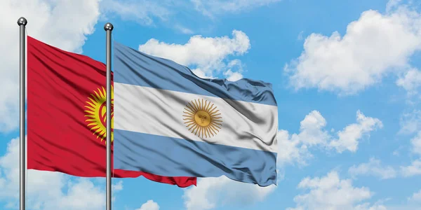 Bandera de Kirguistán y Argentina ondeando en el viento contra el cielo azul nublado blanco juntos. Concepto diplomático, relaciones internacionales . — Foto de Stock
