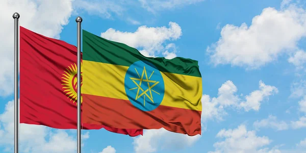 キルギスとエチオピアの旗が一緒に白い曇り青い空に対して風に振る。外交概念、国際関係. — ストック写真