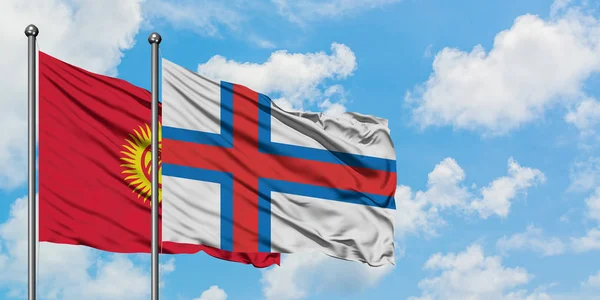 Bandeira do Quirguistão e Ilhas Faroé acenando no vento contra o céu azul nublado branco juntos. Conceito de diplomacia, relações internacionais . — Fotografia de Stock