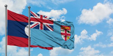 Laos ve Fiji bayrağı birlikte beyaz bulutlu mavi gökyüzüne karşı rüzgarda sallayarak. Diplomasi kavramı, uluslararası ilişkiler.