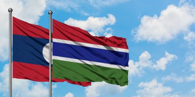 Laos ve Gambiya bayrağı birlikte beyaz bulutlu mavi gökyüzüne karşı rüzgarda sallayarak. Diplomasi kavramı, uluslararası ilişkiler.