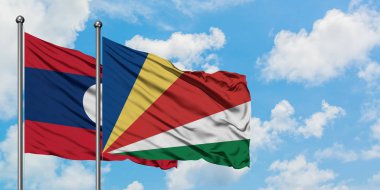 Laos ve Seyşeller bayrak birlikte beyaz bulutlu mavi gökyüzüne karşı rüzgarda sallayarak. Diplomasi kavramı, uluslararası ilişkiler.