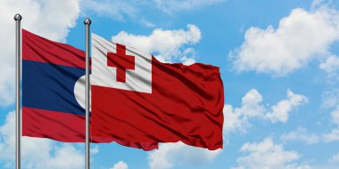 Laos ve Tonga bayrağı birlikte beyaz bulutlu mavi gökyüzüne karşı rüzgarda sallayarak. Diplomasi kavramı, uluslararası ilişkiler.