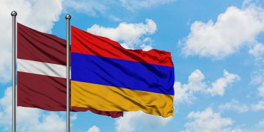Letonya ve Ermenistan bayrağı birlikte beyaz bulutlu mavi gökyüzüne karşı rüzgarda sallayarak. Diplomasi kavramı, uluslararası ilişkiler.