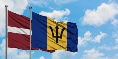Letonya ve Barbados bayrağı birlikte beyaz bulutlu mavi gökyüzüne karşı rüzgarda sallayarak. Diplomasi kavramı, uluslararası ilişkiler.