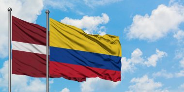 Letonya ve Kolombiya bayrağı birlikte beyaz bulutlu mavi gökyüzüne karşı rüzgarda sallayarak. Diplomasi kavramı, uluslararası ilişkiler.