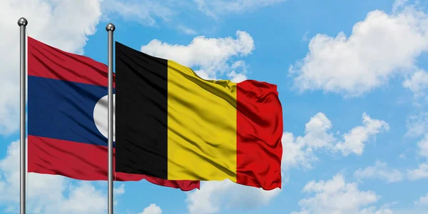 老挝和比利时国旗在风中飘扬，白云蓝天相聚。外交概念、国际关系. — 图库照片
