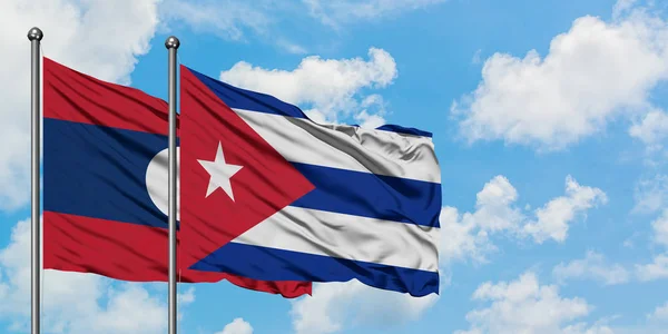 Το Λάος και η Κούβα κυματίζει στον άνεμο ενάντια στον λευκό συννεφιασμένο γαλάζιο ουρανό μαζί. Φιλοσοφία της διπλωματίας, διεθνείς σχέσεις. — Φωτογραφία Αρχείου