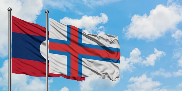 Лаос і Фарерські острови прапор розмахуючи в вітру проти білого хмарного синього неба разом. Концепція дипломатії, міжнародні відносини. — стокове фото