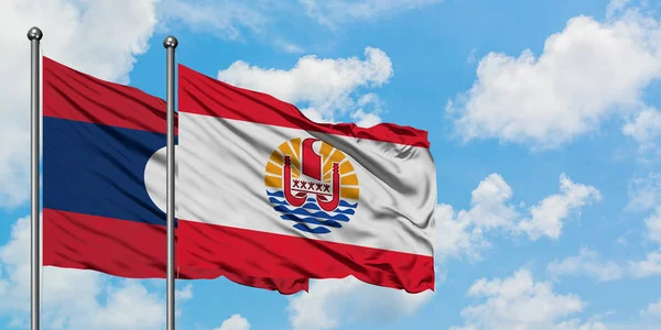 Laos and French Polynesia flag waving in the wind against white cloudy blue sky together. Diplomacy concept, international relations. — Stock Photo, Image