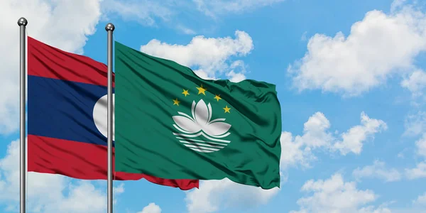 Laos and Macao flag waving in the wind against white cloudy blue sky together. Diplomacy concept, international relations.