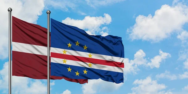 Bandera de Letonia y Cabo Verde ondeando en el viento contra el cielo azul nublado blanco juntos. Concepto diplomático, relaciones internacionales . — Foto de Stock