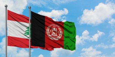 Lübnan ve Afganistan bayrağı birlikte beyaz bulutlu mavi gökyüzüne karşı rüzgarda sallayarak. Diplomasi kavramı, uluslararası ilişkiler.