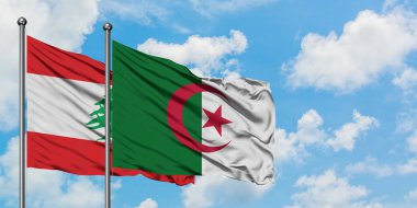 Lübnan ve Cezayir bayrağı birlikte beyaz bulutlu mavi gökyüzüne karşı rüzgarda sallayarak. Diplomasi kavramı, uluslararası ilişkiler.