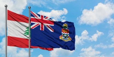 Lübnan ve Cayman Adaları bayrağı birlikte beyaz bulutlu mavi gökyüzüne karşı rüzgarda sallayarak. Diplomasi kavramı, uluslararası ilişkiler.