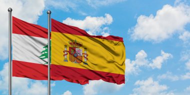 Lübnan ve İspanya bayrağı birlikte beyaz bulutlu mavi gökyüzüne karşı rüzgarsal sallayarak. Diplomasi kavramı, uluslararası ilişkiler.