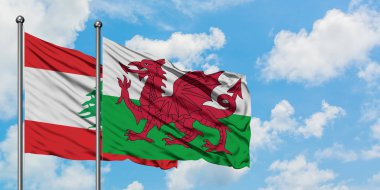 Lübnan ve Galler bayrağı birlikte beyaz bulutlu mavi gökyüzüne karşı rüzgarda sallayarak. Diplomasi kavramı, uluslararası ilişkiler.