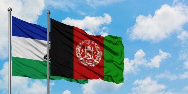 Lesotho ve Afganistan bayrağı birlikte beyaz bulutlu mavi gökyüzüne karşı rüzgarda sallayarak. Diplomasi kavramı, uluslararası ilişkiler.